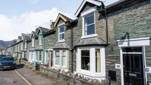 A row of terraced houses with stone facades, a paved driveway, and a parked car. - 2 Bed in Keswick (oc-87732) (Keswick)