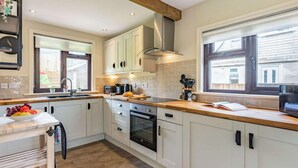 Eine moderne Küche mit weißen Schränken, einer Holz Arbeitsplatte und einem eingebauten Backofen.