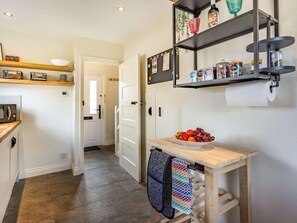 A kitchen with a wooden countertop, a bowl of fruit, and a shelf with jars. - 3 Bed in Rye- (oc-87841) (Camber)