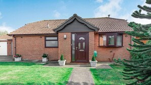 A single-story brick house with a dark brown front door, a small porch, and a tiled roof. - 2 Bed in Mablethorpe (oc-87801) (Mablethorpe)