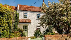 A two-story house with a red-tiled roof, white walls, and a green door. - 2 Bed in Lowestoft (oc-88109) (Lowestoft)