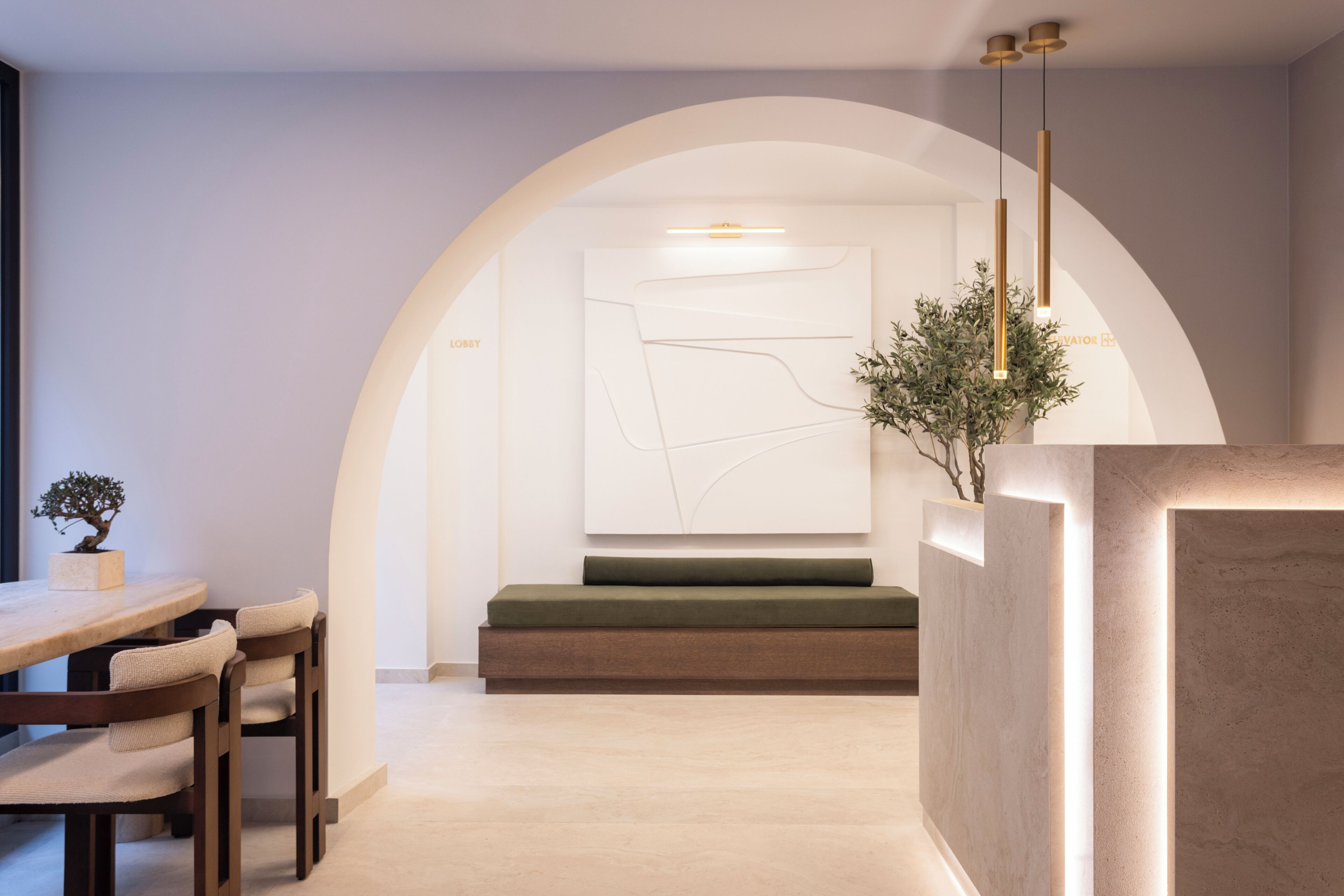 A modern interior with a dining area, a seating bench, and a minimalist wall art piece.