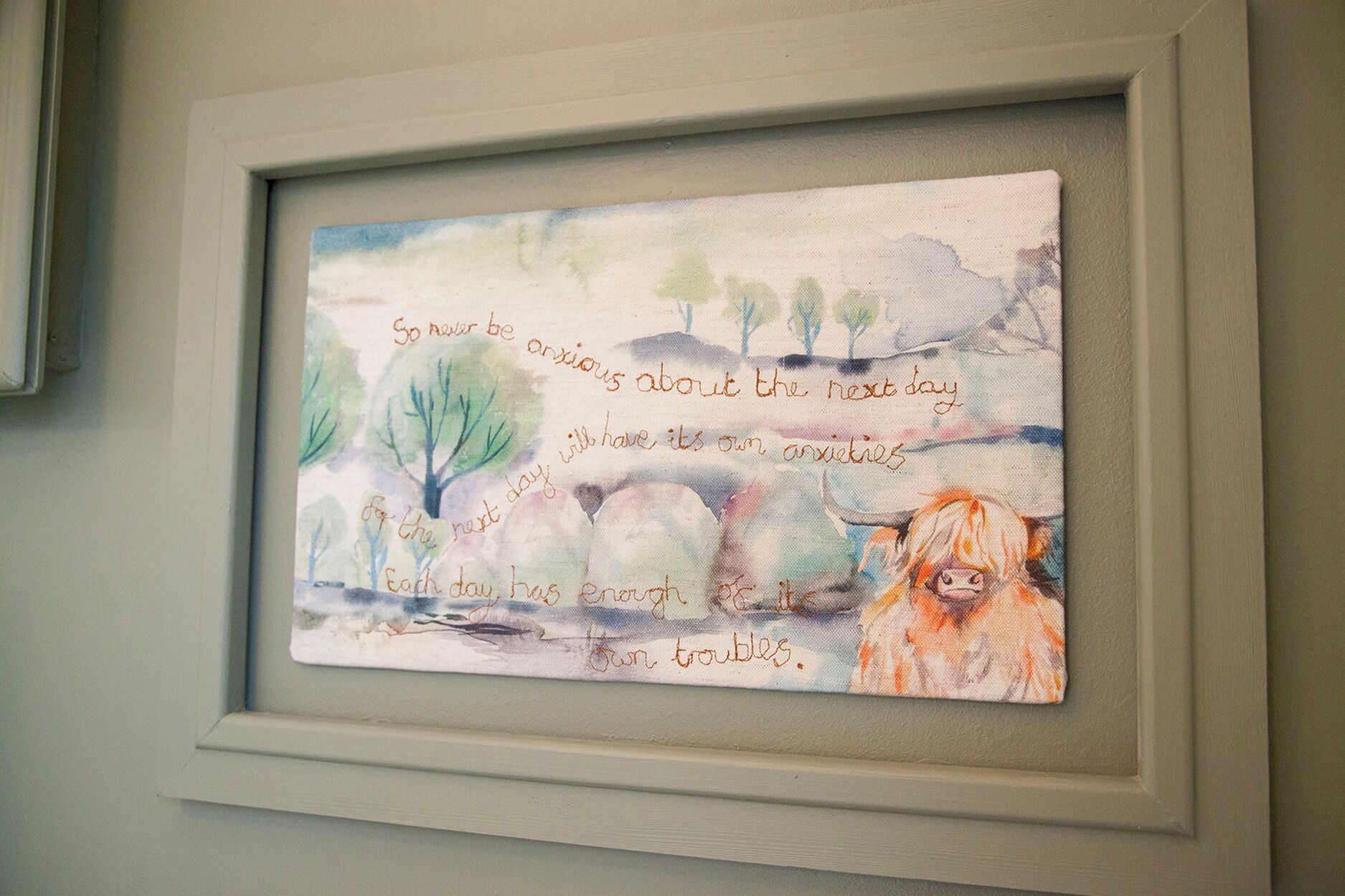 A framed artwork with a landscape and text.