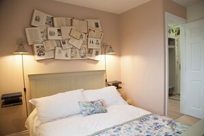 A bedroom with a bed, a wall of books, and a door. - Snug Corner (Holmfirth)