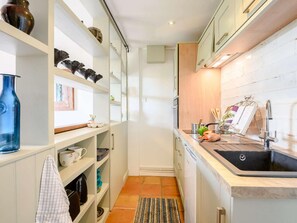 A narrow kitchen with white cabinetry, a black sink, and a tiled backsplash. - 1 Bed in Gillingham (oc-88120) (West Stour)