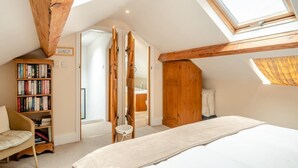 A bedroom with a skylight, a bookshelf, a wooden wardrobe, and a bed. - 2 Bed in Hexham (oc-88032) (Once Brewed)