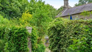 A stone building with a thatched roof, surrounded by lush greenery and ivy. - 2 Bed in Hexham (oc-88032) (Once Brewed)