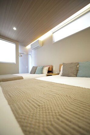 Ein Hotelzimmer mit zwei Betten, einem Fenster und einer Klimaanlage.