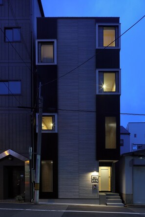 A modern multi-story building with a flat facade, multiple windows, and a visible entrance. - Koti Sopo Universal Bay 4 by Liaison (Minato ward)