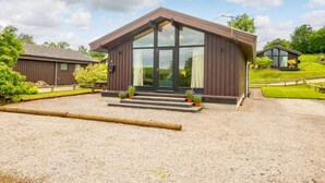 A modern building with a large glass entrance, a gravel driveway, and a well-maintained lawn. - 3 Bed in Penrith (oc-88212) (Yanwath)