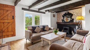 Ein gemütliches Wohnzimmer mit einer Couch, einem Couchtisch und einem Kamin.