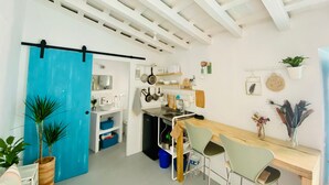 Een keuken met een blauwe deur, witte wanden en een houten plafond.