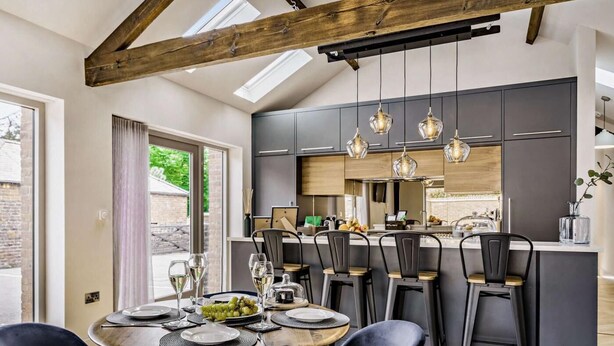 A modern kitchen with dark cabinets, a central island, and pendant lighting. - 2 Bed in Driffield (oc-88238) (Lund)