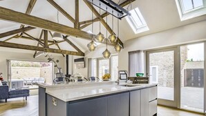 A spacious kitchen with a large island, wooden beams, and pendant lighting. - 2 Bed in Driffield (oc-88238) (Lund)