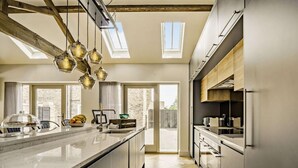 A modern kitchen with a large island, skylights, and a view to the outside. - 2 Bed in Driffield (oc-88238) (Lund)
