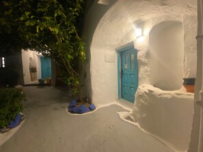 A narrow, white-walled corridor with a blue door and a small window. - Cave apartment in the heart of the center (Vejer de la Frontera)