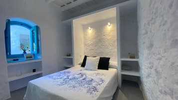 Une chambre à coucher avec un lit, une fenêtre et des étagères intégrées.