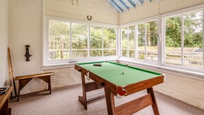A pool table in a room with large windows, a bench, and a white brick wall. - 3 Bed in Bala (oc-88351) (Fron-goch)