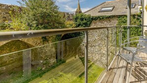 A balcony with a metal railing overlooking a stone bridge and greenery. - 2 Bed in Tenby (oc-88738) (Tenby)