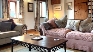 Ein gemütliches Wohnzimmer mit einer Couch, einem Couchtisch und einem Bücherregal.