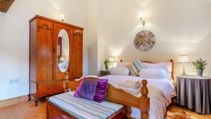 Ein Schlafzimmer mit einem hölzernen Bett, einer Bank, einem Kleiderschrank und einer runden Wanddekoration.