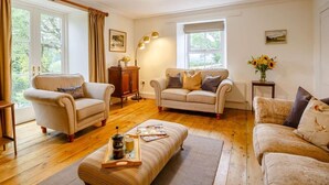 A cozy living room with two sofas, a coffee table, and a floor lamp. - 4 Bed in Corwen (oc-88868) (Corwen)