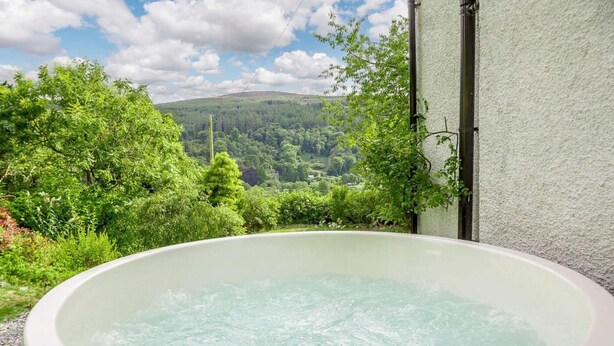 A hot tub with a view of a forested hillside. - 4 Bed in Corwen (oc-88868) (Corwen)
