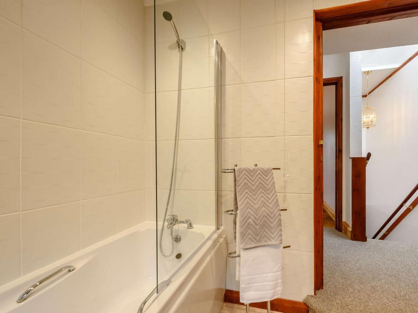 A bathroom with a bathtub, a shower, and a towel rack.