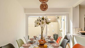 Ein Esstisch mit Tellern, Schüsseln, Gläsern und einer Blumenvase.
