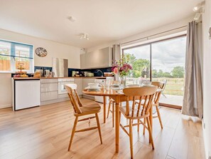 A modern kitchen with a dining area, large windows, and a view of the outdoors. - 2 Bed in Malmesbury (oc-89025) (Minety)