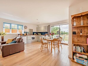 A modern kitchen with a dining area, a bookshelf, and a view of the outdoors. - 2 Bed in Malmesbury (oc-89025) (Minety)