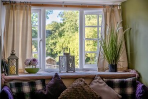 A window seat with a view of greenery, a lantern, a decorative metal lantern, and a potted plant. - 1 Bed in Hexham (oc-89085) (Bellingham)