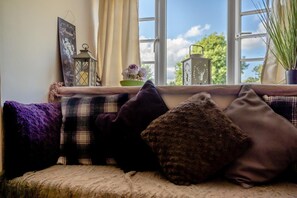 Eine gemütliche Sitzecke mit Fensterblick, einer Zierlaterne und einem Blumentopf.