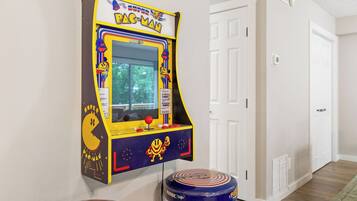 Ein Pac-Man-Spielgerät, eine Tür und ein Sitzhocker mit Muster.