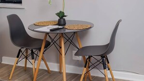 Ein Essbereich mit einem runden Tisch, zwei Stühlen, einer Blumenvase und sechseckigen Wanddekorationen.