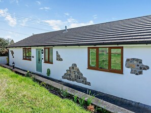 A white building with stone accents, a green door, and windows with brown frames. - 2 Bed in Axminster (oc-89471) (Tytherleigh)