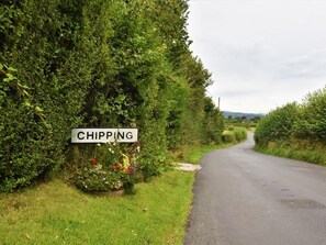 A rural road with a sign reading 'CHIPPING' and a flower bed on the side. - 2 Bed in Preston (oc-89536) (Chipping)