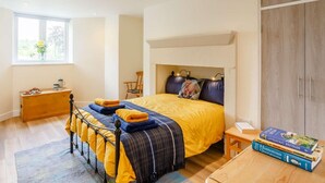 A bedroom with a bed, bedside table, books, a window, and a wardrobe. - 2 Bed in Ilkley (oc-89554) (Ilkley)