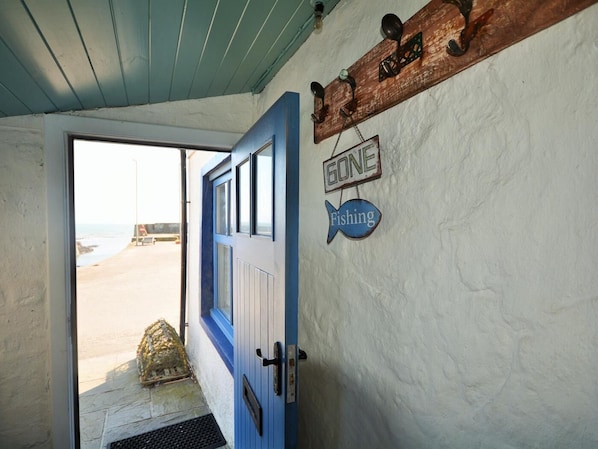 Una puerta con marco azul, un letrero que dice 'GONE Fishing' y otro que dice 'GONE' encima.
