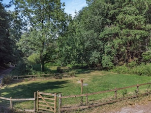 A fenced outdoor area with a grassy field, trees, and a wooden gate. - 1 Bed in Newton Abbot (oc-bbell) (Hennock)