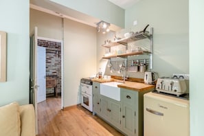A compact kitchen with a stove, oven, and a vintage-style toaster. - 1 Bed in Newton Abbot (oc-bbell) (Hennock)