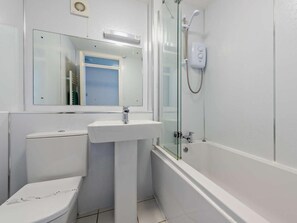 Een badkamer met toilet, wastafel en douche.