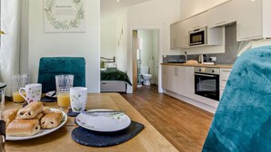 Une cuisine moderne avec des meubles blancs, un four à micro-ondes et une cuisinière.
