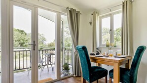 Un espace repas comprenant une table, des chaises et donnant sur l’extérieur.