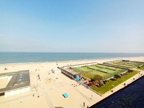 En strandutsikt med en tennisbana och en byggnad med ett platt tak.