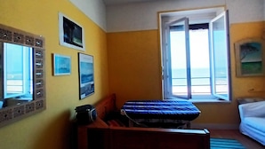 Ein Zimmer mit Bett, Schreibtisch, Fenster mit Blick und Wanddekorationen.