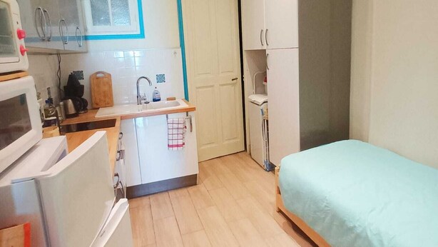 Ein gemütlicher Raum mit Küchenzeile, einem Bett und einem Kleiderschrank.