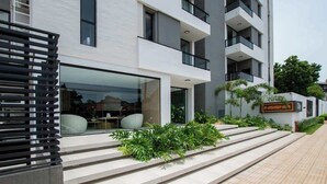 A modern building with a glass entrance, outdoor seating, and a sign reading 'INSIGNIA City.' - Corporate Stays Insignia City - A44 (Asunción)