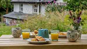 Ein Frühstückstisch mit Croissants, Orangensaft und einer Teekanne.