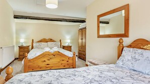 A bedroom with a wooden bed, a bedside table with a lamp, a wardrobe, and a mirror on the wall. - 2 Bed in Brecon (oc-bn138) (Bwlch)